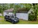 Outbuilding exterior showing aging siding, complemented by a black SUV parked on a green, grassy lot at 1217 S Highway 501, Marion, SC 29571