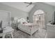 Bright bedroom with a tall arched window, large bed, and a desk for working at home at 1323 Ashboro Ct., Myrtle Beach, SC 29579