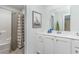 Bright bathroom featuring white cabinets, gray tile floor, shower and giraffe wall art at 1429 Nokota Dr., Conway, SC 29526