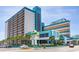 Exterior view of Landmark Resort; shows the building and sign with landscaping and parked cars in front at 1501 S Ocean Blvd. # 805, Myrtle Beach, SC 29577