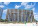 A large beachfront resort building with multiple floors of condos with balconies and palm trees, taken from the beach at 1501 S Ocean Blvd. # 805, Myrtle Beach, SC 29577