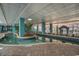 Indoor lazy river features blue tile, an island with trees, and lounge seating under a glass ceiling at 1501 S Ocean Blvd. # 805, Myrtle Beach, SC 29577