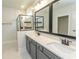 Bright bathroom boasts double vanity with stone counters and modern fixtures, plus walk-in shower with glass door at 1514 Saw Palmetto St., North Myrtle Beach, SC 29582