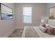 Neutral bedroom features hardwood flooring, a window, and a comfortable bed at 1514 Saw Palmetto St., North Myrtle Beach, SC 29582