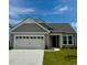 Charming single-story home features a two-car garage, gray siding, and a well-manicured lawn under a clear blue sky at 1514 Saw Palmetto St., North Myrtle Beach, SC 29582