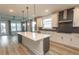 Modern kitchen with white cabinets, gray backsplash, a large island, and stainless steel appliances at 1514 Saw Palmetto St., North Myrtle Beach, SC 29582