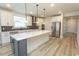 Gourmet kitchen with a gray island, stainless steel appliances, and white cabinetry provides a bright aesthetic at 1514 Saw Palmetto St., North Myrtle Beach, SC 29582