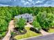 An aerial view showcases a two-story home surrounded by lush greenery and a well-manicured yard at 155 Preservation Circle, Pawleys Island, SC 29585