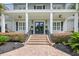 Elegant front entrance featuring a brick staircase, double doors, and charming porch swings at 155 Preservation Circle, Pawleys Island, SC 29585