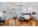 Luxurious main bedroom with tray ceilings, elegant chandelier, and large window with shutters for serene ambiance at 155 Preservation Circle, Pawleys Island, SC 29585