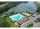 Aerial shot showcasing the community pool, lake, clubhouse, and surrounding lush landscape at 160 Juniata Loop, Little River, SC 29566