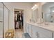 Well-lit bathroom with dual vanity, walk-in shower, and access to a walk-in closet at 160 Juniata Loop, Little River, SC 29566