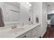 Bright bathroom featuring double sinks, white cabinets, framed mirrors, and modern fixtures at 1725 26Th Ave N, North Myrtle Beach, SC 29582