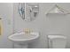 Powder room featuring a pedestal sink, round mirror, modern toilet, and white paint at 1725 26Th Ave N, North Myrtle Beach, SC 29582