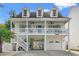 Charming two-story beach home featuring a spacious covered porch, white picket railings, and well-maintained landscaping at 1725 26Th Ave N, North Myrtle Beach, SC 29582