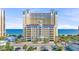 Stunning view of the yellow condo building with palm trees and access to a beautiful beach at 2000 N Ocean Blvd. # 1209, Myrtle Beach, SC 29577