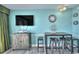 Cozy living space with a TV, retro decor, bar stools, and blue walls providing a relaxed environment at 2000 N Ocean Blvd. # 1209, Myrtle Beach, SC 29577