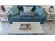 Comfortable living room with a blue sofa, pillows and a wooden coffee table on a decorative rug at 2001 S Ocean Blvd. S # 1302, Myrtle Beach, SC 29577