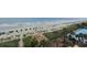 Expansive beach aerial view with clear ocean, sandy shoreline, swimming pool, and palm trees at 2007 S Ocean Blvd. # 604, Myrtle Beach, SC 29577