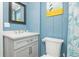 Bathroom featuring a vanity, toilet, and blue wooden paneling at 202 27Th Ave. N, North Myrtle Beach, SC 29582