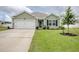 Inviting one-story home with lush green lawn, front yard landscaping, and attached garage at 211 Seasons Trace Loop, Longs, SC 29568