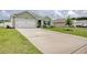 Charming one-story home featuring an attached garage, well-maintained lawn, and a spacious concrete driveway at 211 Seasons Trace Loop, Longs, SC 29568