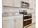 Modern kitchen with white cabinets, granite countertops, and stainless steel appliances including range and microwave at 211 Seasons Trace Loop, Longs, SC 29568