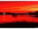 Scenic view of a vibrant sunset over the water with lights reflecting, casting a fiery glow at 2196 Liberty Circle, Little River, SC 29566