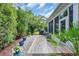 Landscaped backyard featuring a paved patio, colorful planters, and mature trees at 2199 Birchwood Circle, Myrtle Beach, SC 29577
