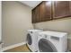 Convenient laundry room equipped with front-load washer and dryer and upper cabinets for storage at 2199 Birchwood Circle, Myrtle Beach, SC 29577