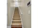 Carpeted staircase with white railings leading to the upper level of the home, showcasing natural light at 2199 Birchwood Circle, Myrtle Beach, SC 29577