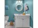 Powder room with blue walls features a white vanity, a round mirror, and decorative accents at 2336 Tidewatch Way, North Myrtle Beach, SC 29582