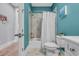 Bathroom featuring a shower/tub combo with a white curtain, blue walls, and tiled floors at 2336 Tidewatch Way, North Myrtle Beach, SC 29582