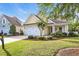 Charming home boasts a manicured lawn and vibrant landscaping, complemented by a two-car garage at 2336 Tidewatch Way, North Myrtle Beach, SC 29582