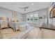 A large main bedroom with a king bed, a sitting bench, and two dressers near large windows at 2336 Tidewatch Way, North Myrtle Beach, SC 29582