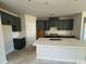 Modern kitchen features sleek gray cabinetry, stainless appliances, and a large island with sink at 3012 Palma Way, Myrtle Beach, SC 29579