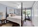 Bedroom features four poster bed, ceiling fan and bright window with a treadmill at 312 S Poplar Ave., Andrews, SC 29510