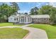 Exterior elevation of a brick and siding home features a metal roof and well-maintained landscaping at 312 S Poplar Ave., Andrews, SC 29510
