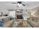 Cozy living room with a fireplace, TV, ceiling fan, and an open layout to the kitchen at 312 S Poplar Ave., Andrews, SC 29510
