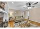 Cozy living room featuring a fireplace, neutral walls, a ceiling fan, and hardwood flooring at 312 S Poplar Ave., Andrews, SC 29510
