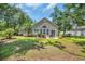 A private patio is nestled against the house in a lush backyard surrounded by mature trees and landscaping at 327 Trestle Way, Conway, SC 29526