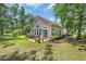 A private patio is nestled against the house in a lush backyard surrounded by mature trees and landscaping at 327 Trestle Way, Conway, SC 29526