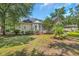 Rear exterior view of home featuring a private patio and lush backyard with mature trees and landscaping at 327 Trestle Way, Conway, SC 29526