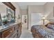 Bedroom with a large dresser, mirror, candles and a doorway to the hallway with cream colored walls and carpet at 327 Trestle Way, Conway, SC 29526