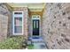 Close-up of the home's entryway with a black door, sidelight window, and classic brick surround at 327 Trestle Way, Conway, SC 29526