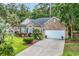 Charming brick home with a manicured lawn, lush landscaping, and a two-car garage at 327 Trestle Way, Conway, SC 29526