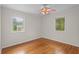 Well-lit bedroom with windows, hardwood floors, ceiling fan, and neutral paint at 3534 Nichols Hwy., Galivants Ferry, SC 29544
