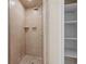 Tiled shower with shelving, shower head, and adjacent linen closet at 3534 Nichols Hwy., Galivants Ferry, SC 29544