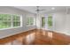 Bright sunroom with hardwood floors, ceiling fan, windows and sliding glass door access to the outdoors at 3534 Nichols Hwy., Galivants Ferry, SC 29544