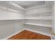 Walk-in closet featuring wood flooring and white built-in shelving at 3534 Nichols Hwy., Galivants Ferry, SC 29544